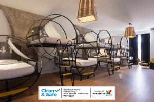 a room with a group of bunk beds and chairs at The House of Sandeman - Hostel & Suites in Vila Nova de Gaia