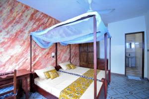 a bedroom with a bed with a canopy at B&B Chez Rita in Cotonou