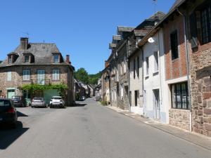 una calle vacía en un viejo pueblo con edificios en La mémée du Saillant, en Voutezac