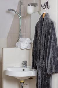 a bathroom with a towel hanging on a sink at Pure Passie Bed and Breakfast in Willemstad