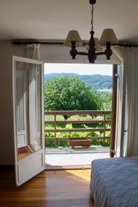 a bedroom with a door open to a porch with a view at Caserio en Zona Rural Istilla in Hondarribia