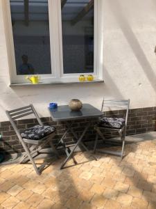 una mesa y dos sillas sentadas junto a una ventana en Doros Ferienoase, en Herzogenrath