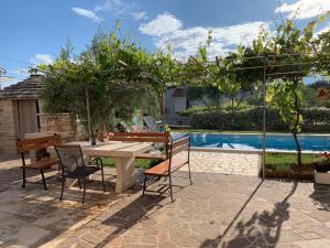 a patio with a table and chairs next to a pool at Apartments Leone in Brtonigla