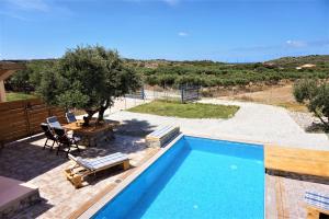 een zwembad in een tuin met een tafel en stoelen bij Sea Lake Holiday House in Elafonisi