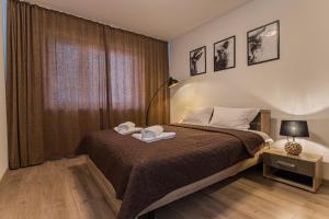 1 dormitorio con 1 cama con 2 toallas en Coresi modern apartment, en Brasov