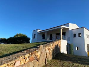 una casa en una colina con una pared de piedra en la casa della tartaruga, en San Pantaleo