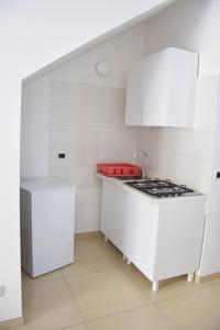 a kitchen with white cabinets and a stove at la casa di Marco in Canosa di Puglia