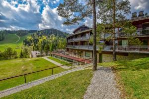 a building on a hill with a field and trees at Hotel SPA Dr Irena Eris Krynica Zdrój in Krynica Zdrój