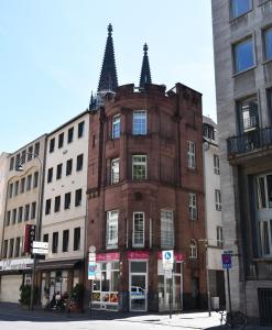 un vecchio edificio in mattoni all'angolo di una strada di DOM APARTS a Colonia