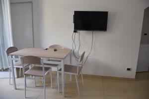 a table and chairs with a television on a wall at la casa di Marco in Canosa di Puglia +12 photos