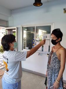 une femme prenant une photo d'une femme portant un masque dans l'établissement UJ apartment, à Bang Saen