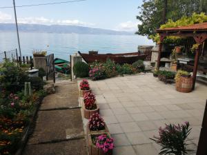 een tuin met bloemen en uitzicht op het water bij Blue Bay Guest House in Trpejca