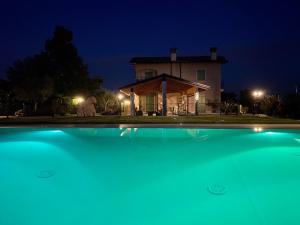 una casa di notte con una piscina di fronte di Poggio Bardolino a Bardolino