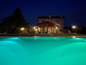 a house at night with a swimming pool in front of it at Poggio Bardolino in Bardolino