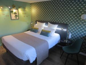 - une chambre avec un grand lit blanc et une chaise dans l'établissement Hôtel Kyriad Cap Sud, à Avignon