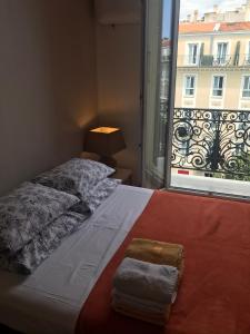 sypialnia z łóżkiem i oknem z widokiem w obiekcie Studios Floreal w Nicei