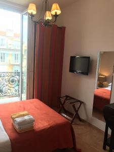 a room with a bed and a mirror and a television at Studios Floreal in Nice