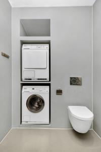 a bathroom with a washing machine and a toilet at Central Studio Apartment Apt 202 in Stavanger