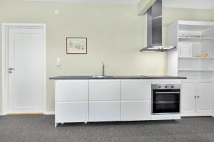 a white kitchen with a sink and a stove at Central Studio Apartment Apt 202 in Stavanger