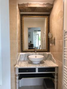 a bathroom with a sink and a mirror at le Logis du Plessis in Chaniers