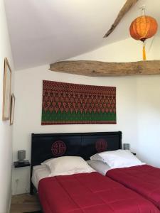 een slaapkamer met 2 bedden en rode lakens bij le Logis du Plessis in Chaniers