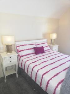 a bedroom with a bed with a purple pillow and two night stands at The Barn @Ardhill House in Ardara