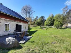 a building with a picnic table next to a yard at Gyttja Västergårds in Nauvo