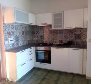 a kitchen with white cabinets and a stove at Residence Covo degli Dei in Milazzo