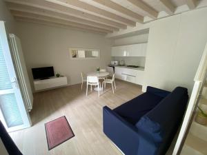 uma sala de estar com um sofá azul e uma mesa em Welcome Traveller LEA APARTMENTS em Garda