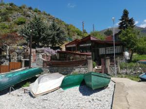 a house with two kayaks on the gravel in front of it at Blue Bay Guest House in Trpejca