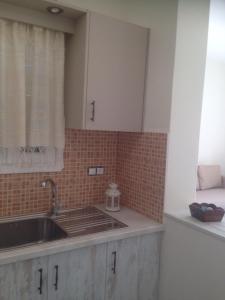 a kitchen counter with a sink and a window at Cycladic houses in rural surrounding in Amorgos