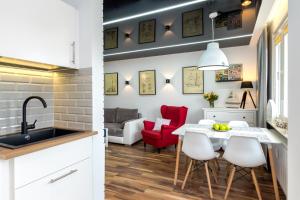 a kitchen and a living room with a table and chairs at Apartamenty Usteckie Wczasowa in Ustka