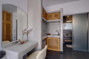 a kitchen with a table with a vase of flowers on it at Beach Houses Santorini in Kamari