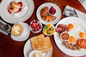 - une table avec des assiettes de petit-déjeuner dans l'établissement Kravt Sadovaya Hotel, à Saint-Pétersbourg