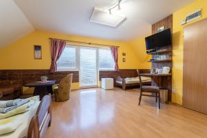 a living room with yellow walls and a large window at Penzión & Bar NATALI in Spišský Štvrtok