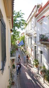 a group of people walking down a street between buildings at Athenian House in Plaka Villa by Athenian Homes in Athens