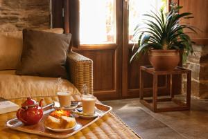 a coffee table with two plates of food and two cups of coffee at Hotel Valle del Silencio in San Esteban de Valdueza