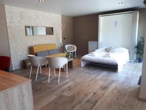 um quarto com uma cama, uma mesa e cadeiras em Au Paradis Guesthouse em Waregem