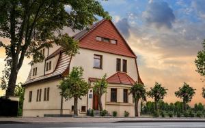 une grande maison blanche avec un toit rouge dans l'établissement Apartamenty, Boutique Rooms Villa 82, Parking, à Gorzów Wielkopolski