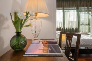 a table with a vase of flowers and a lamp on it at Castle View Room in Verona
