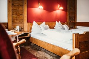 2 camas en una habitación con una persona sentada en una mesa en Hotel Jakob, en Füssen