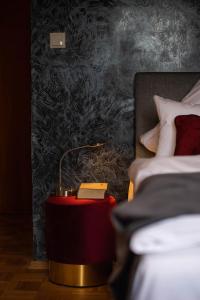 a red table with a lamp next to a bed at Landgasthof Hittenkirchen in Bernau am Chiemsee