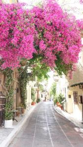 una calle vacía con flores rosas colgando sobre ella en Athenian House in Plaka Villa by Athenian Homes en Athens