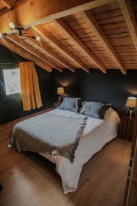 a large bed in a bedroom with wooden ceilings at Le petit coin de Jeanne et Marcel chalet de vacances La Bresse in La Bresse