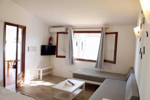 a living room with a couch and a window at Villas Las Alondras in Cala en Forcat