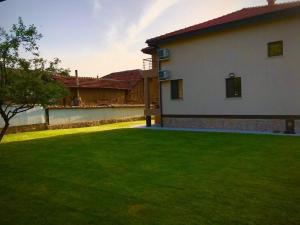 dom z zielonym trawnikiem przed nim w obiekcie Sirakovata Kushta w mieście Saparewa Banja