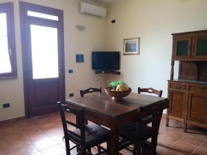jadalnia ze stołem z krzesłami i telewizorem w obiekcie Agriturismo Catena w mieście Cirò