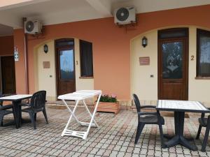 grupa stołów i krzeseł przed budynkiem w obiekcie Agriturismo Catena w mieście Cirò