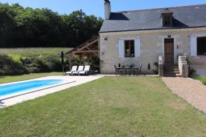 a house with a swimming pool in front of it at La Tale in Chahaignes