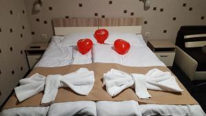 Una cama con dos corazones y toallas. en Sirakovata Kushta en Sapareva Banya